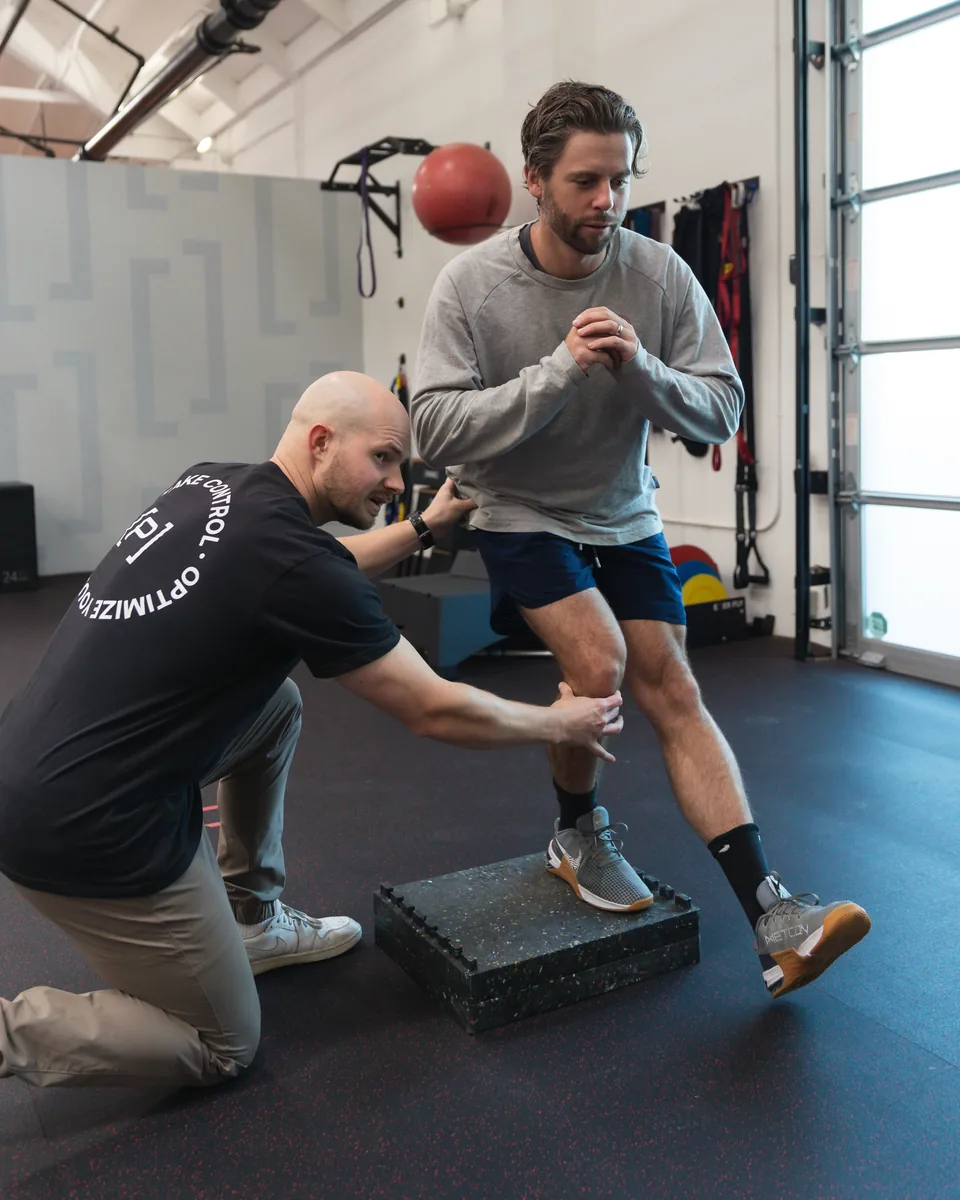 A Prehab physical therapist spotting a patient during a step-down exercise